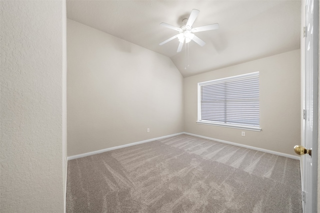 carpeted spare room with ceiling fan and vaulted ceiling