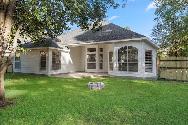 rear view of house featuring a patio, an outdoor fire pit, and a lawn