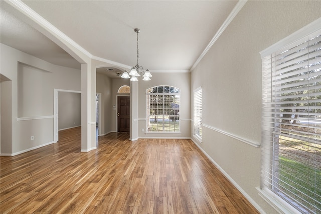 unfurnished dining area featuring ornamental molding, a chandelier, and wood-type flooring