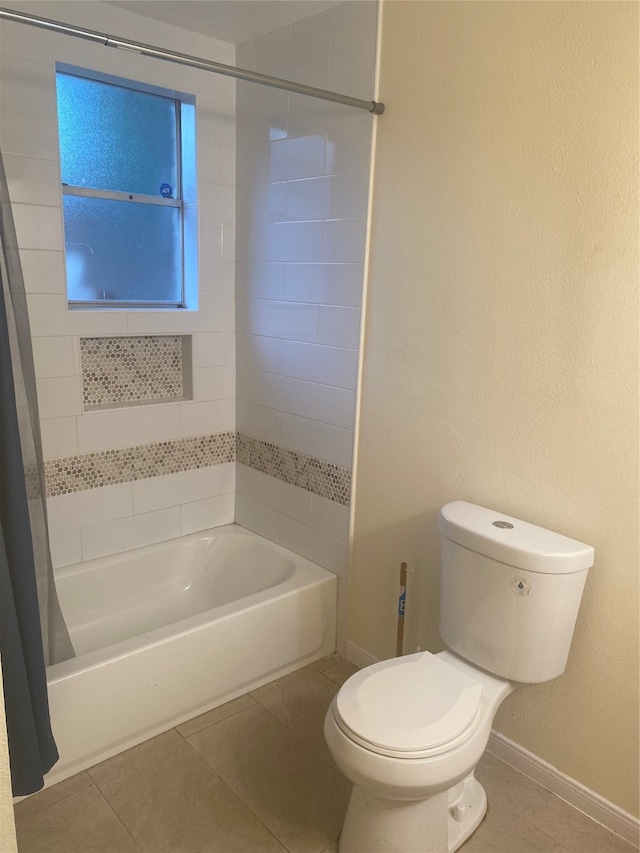 bathroom featuring shower / bath combo with shower curtain, toilet, and tile patterned flooring