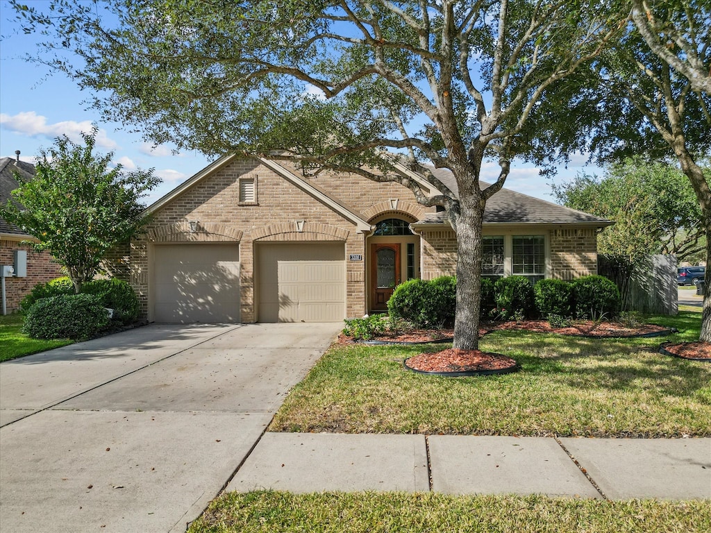 single story home featuring a front yard and a garage