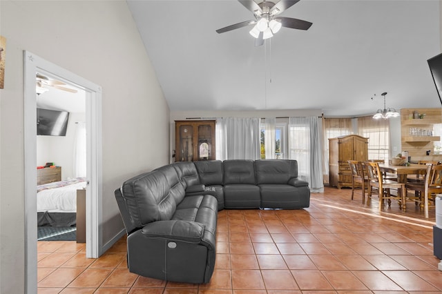 living room with tile patterned floors, ceiling fan with notable chandelier, and vaulted ceiling