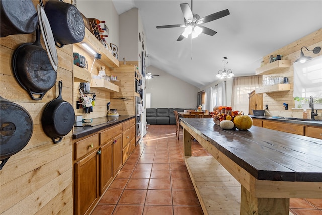 kitchen with lofted ceiling, black electric cooktop, tile patterned flooring, backsplash, and sink