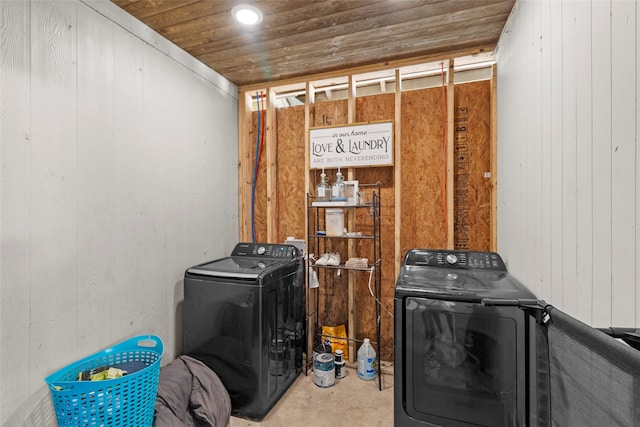 clothes washing area with wood walls, carpet flooring, wooden ceiling, and washing machine and clothes dryer