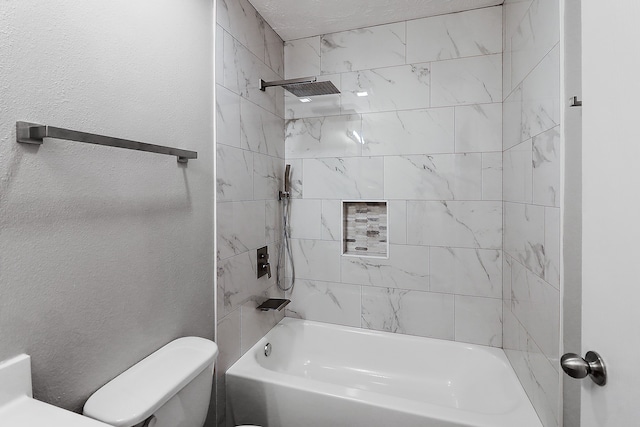 bathroom featuring tiled shower / bath combo and toilet