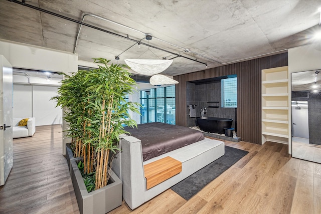 bedroom featuring hardwood / wood-style flooring and wood walls