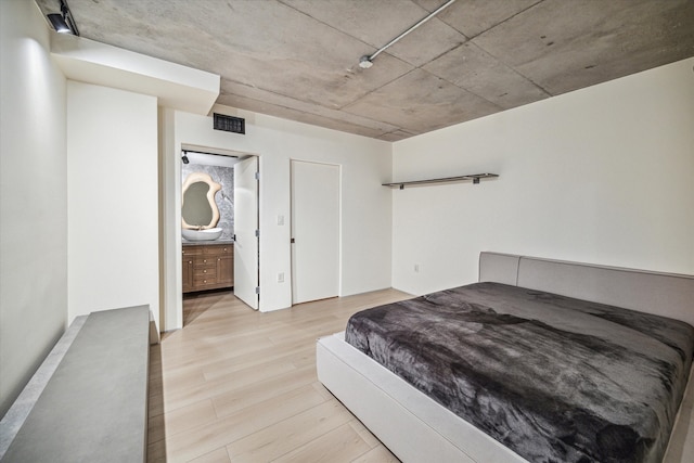 bedroom featuring light hardwood / wood-style floors and ensuite bathroom