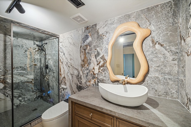 bathroom with a tile shower, toilet, tile walls, and vanity