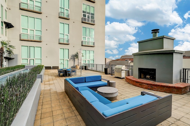 view of patio featuring an outdoor living space with a fireplace and a grill