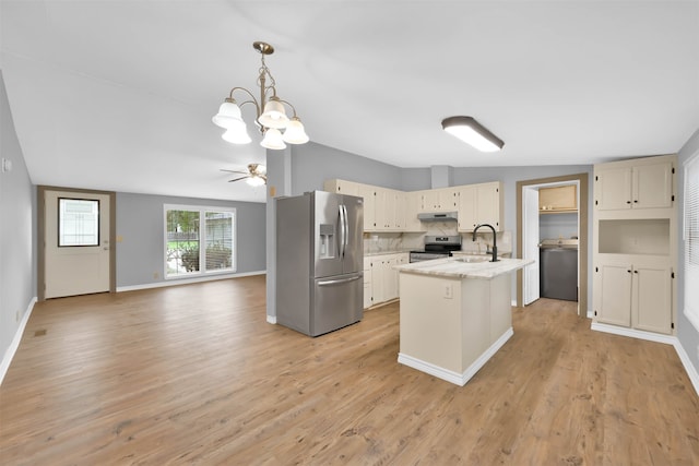 kitchen featuring tasteful backsplash, light stone counters, a center island with sink, stainless steel appliances, and light wood-type flooring