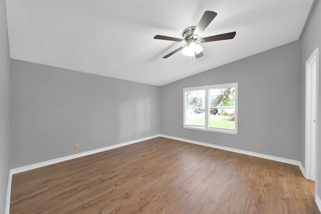 empty room with lofted ceiling, hardwood / wood-style flooring, and ceiling fan