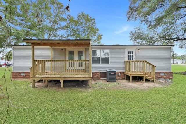 back of property featuring central air condition unit, a lawn, and a deck