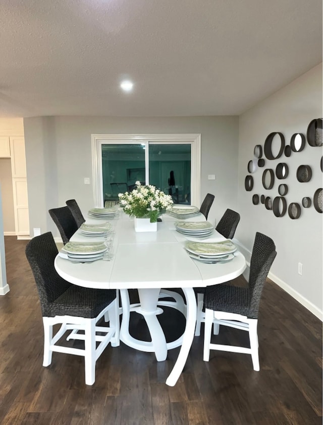 dining room with dark wood-type flooring and a textured ceiling