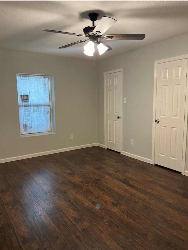 unfurnished room with dark wood-type flooring, ceiling fan, and a textured ceiling