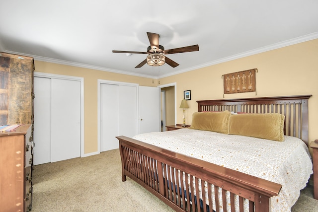 bedroom featuring two closets, light colored carpet, ceiling fan, and crown molding