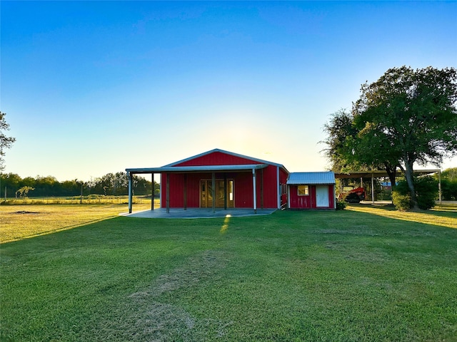 outdoor structure at dusk featuring a yard