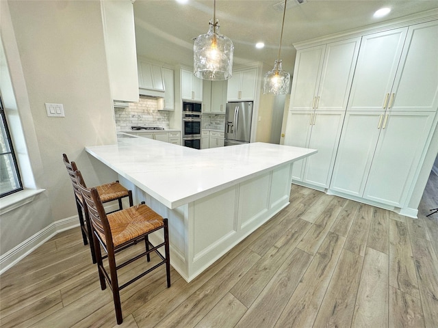 623 Barkaloo Rd, Baytown, TX 77521 - kitchen with light countertops, light wood-style flooring, appliances with stainless steel finishes, and a breakfast bar