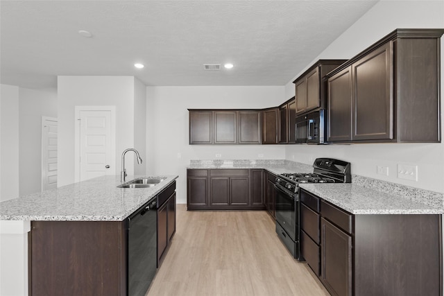 kitchen with black appliances, sink, dark brown cabinets, light hardwood / wood-style floors, and light stone counters