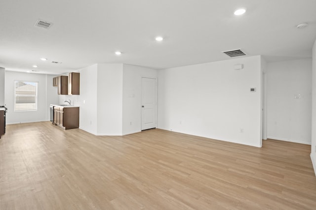 unfurnished living room with sink and light wood-type flooring