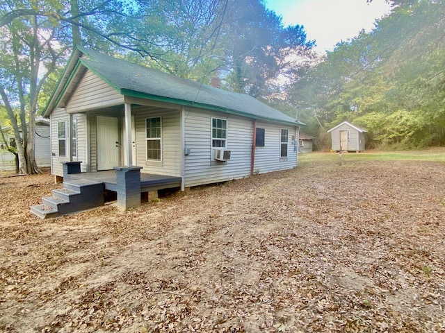 view of side of property featuring cooling unit and a storage shed