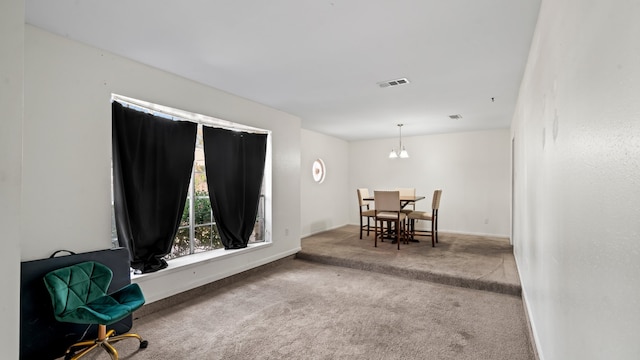 carpeted dining room featuring a notable chandelier