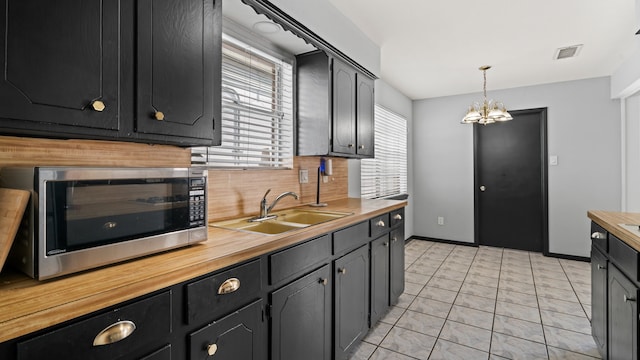 kitchen featuring a healthy amount of sunlight, sink, and butcher block countertops