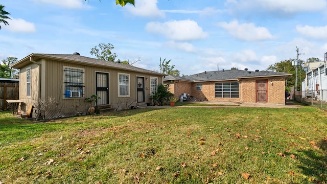 rear view of property featuring a patio and a lawn