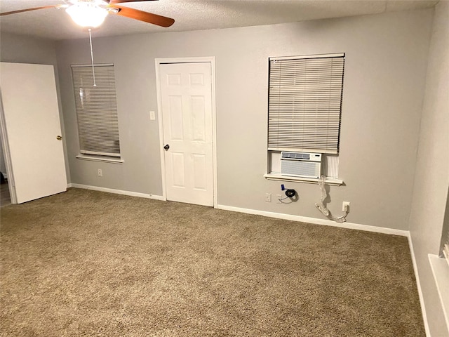 empty room featuring dark carpet, cooling unit, a textured ceiling, and ceiling fan