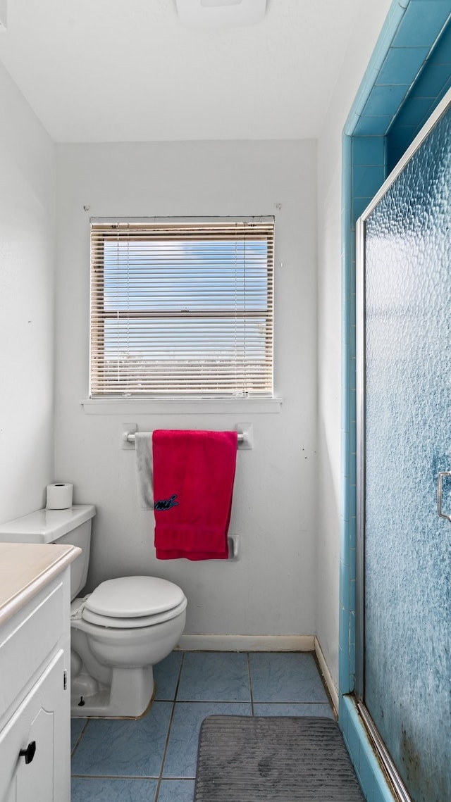 bathroom featuring vanity, a shower with shower door, toilet, and plenty of natural light