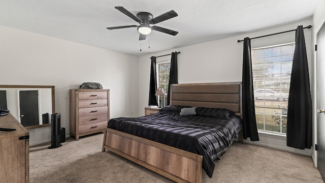 bedroom featuring light carpet, a textured ceiling, and ceiling fan