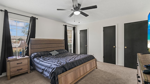 carpeted bedroom with a textured ceiling and ceiling fan