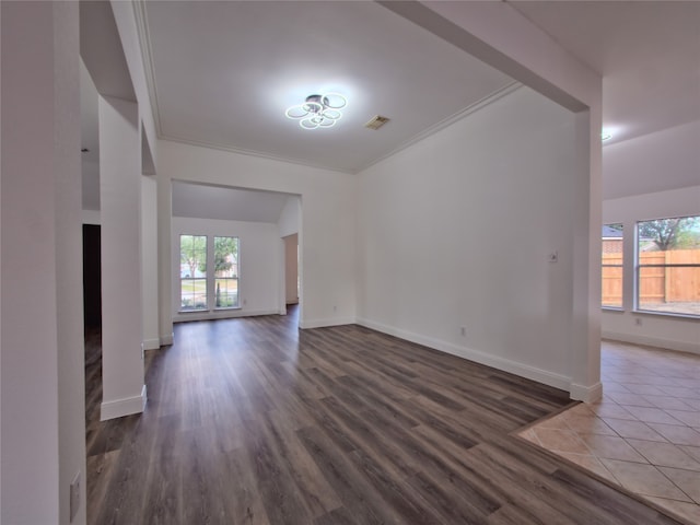 unfurnished living room with dark hardwood / wood-style flooring and ornamental molding