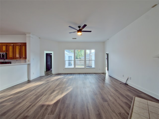 unfurnished living room featuring hardwood / wood-style floors and ceiling fan