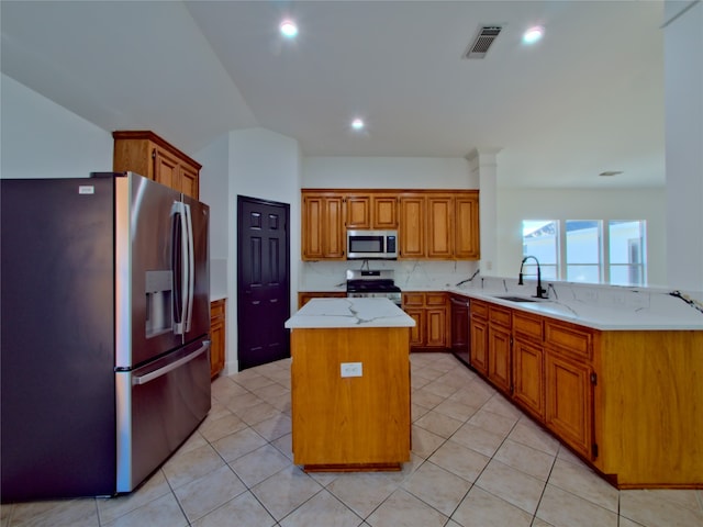 kitchen with stainless steel appliances, light tile patterned floors, sink, and a center island