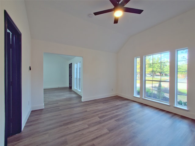 empty room with ceiling fan, light hardwood / wood-style flooring, and vaulted ceiling