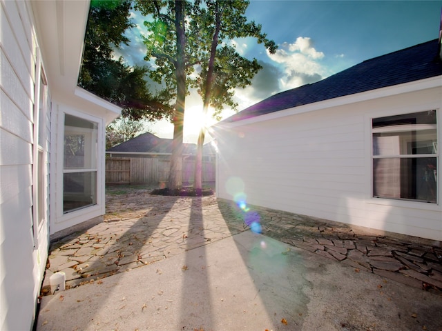 property exterior at dusk featuring a patio