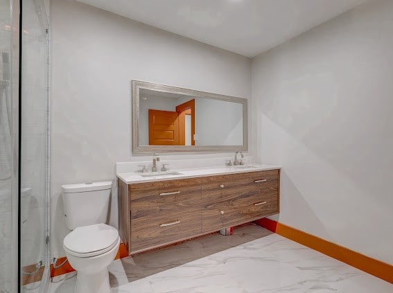 bathroom featuring vanity, toilet, and an enclosed shower