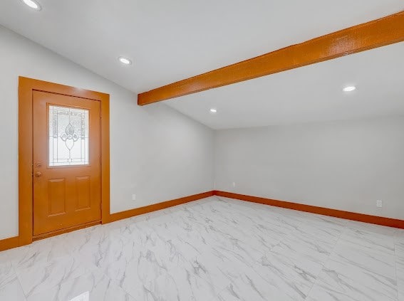 foyer entrance featuring vaulted ceiling with beams