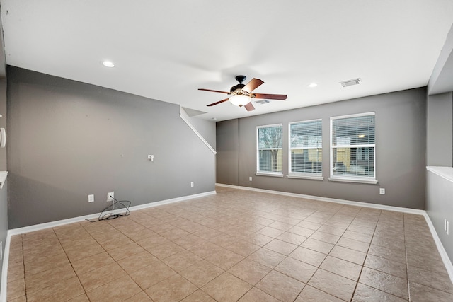 tiled empty room featuring ceiling fan