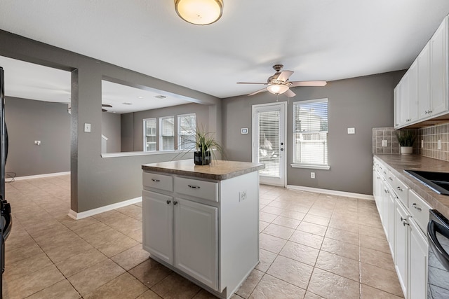 kitchen with decorative backsplash, white cabinetry, and a wealth of natural light