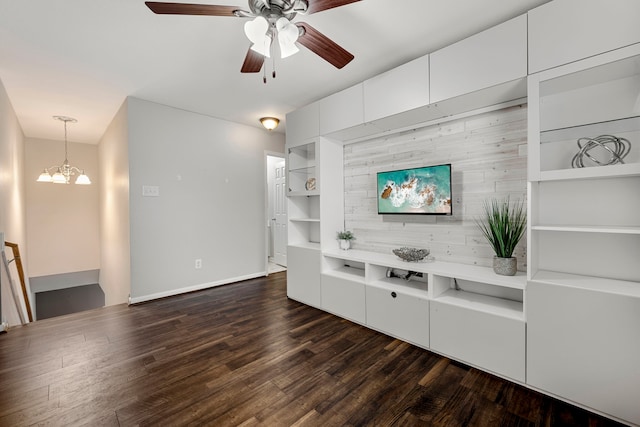 living room with dark wood-type flooring and ceiling fan with notable chandelier