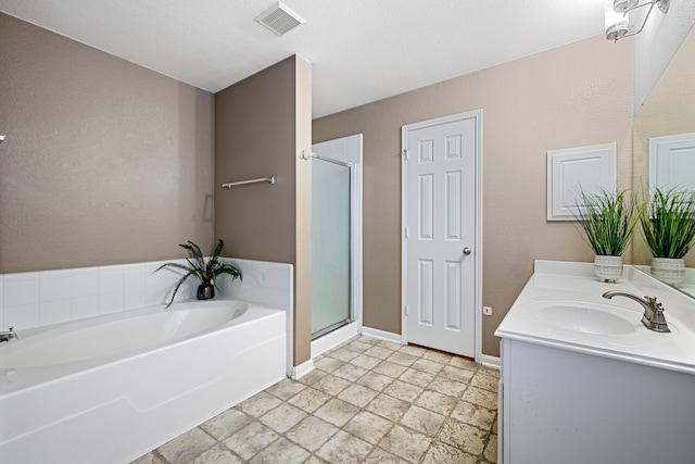 bathroom featuring vanity and independent shower and bath