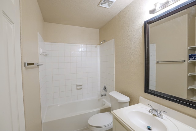 full bathroom featuring vanity, toilet, tiled shower / bath combo, and a textured ceiling