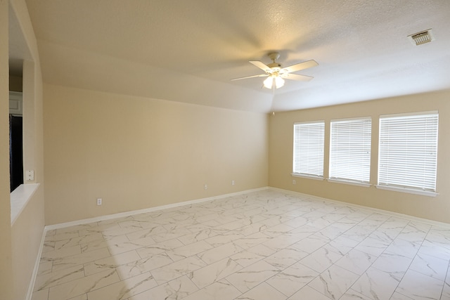 empty room with a textured ceiling and ceiling fan