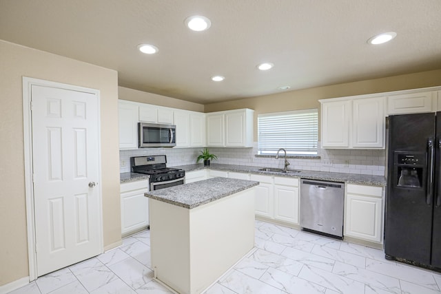 kitchen featuring sink, a kitchen island, white cabinetry, and stainless steel appliances