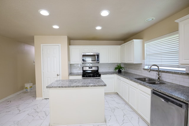 kitchen featuring a center island, appliances with stainless steel finishes, sink, and white cabinets