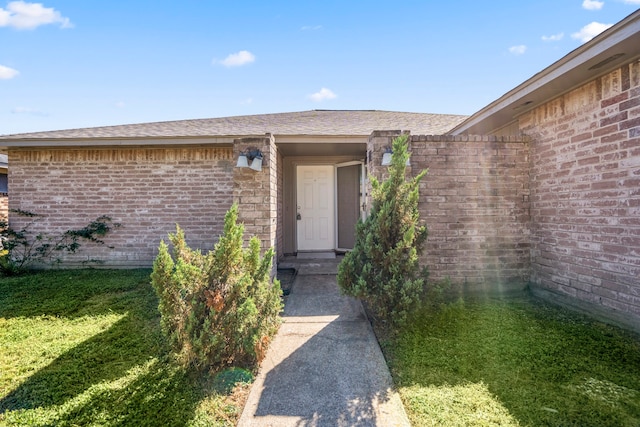 entrance to property with a lawn