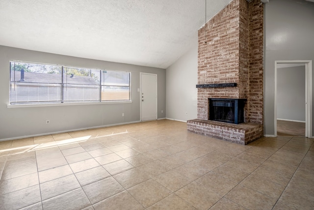 unfurnished living room with a brick fireplace, light tile patterned flooring, a textured ceiling, and lofted ceiling