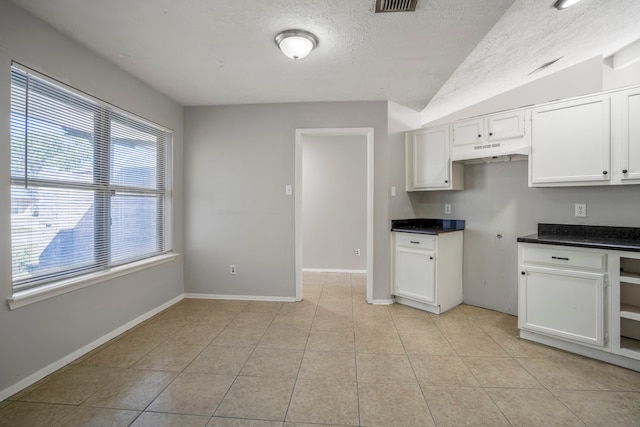 kitchen featuring white cabinetry, a textured ceiling, and light tile patterned floors