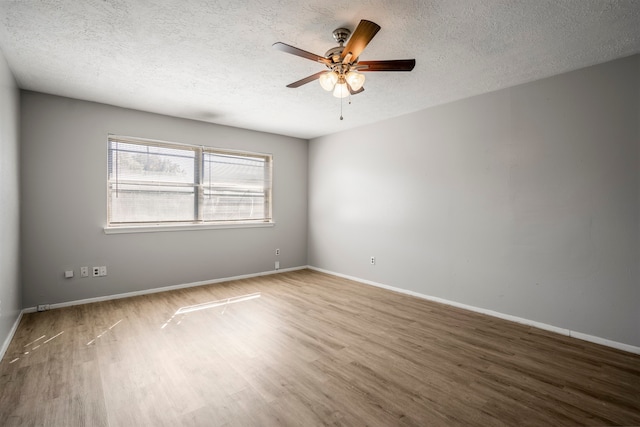 empty room with hardwood / wood-style flooring, ceiling fan, and a textured ceiling